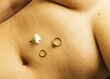 © Sophia Hsin/Stocksy - Jewelry and jasmine flower on belly button