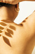 © Sophia Hsin/Stocksy - Leafy shadow on a young womans' bare back