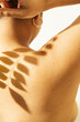 © Sophia Hsin/Stocksy - Leafy shadow on a young womans' bare back