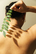© Sophia Hsin/Stocksy - Leafy shadow on a young womans' bare back