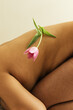 © Sophia Hsin/Stocksy - Tulip balanced on bare skin and curves