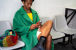 © Alba Vitta/Stocksy - Crop fashion black man using phone in lobby