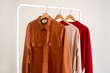 © Lyuba Burakova/Stocksy - Warm tones clothes hanging on a rail