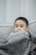 © Pattarakrich - boy wearing a blanket and watching tv