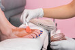 © Shava Cueva/Stocksy - female hands with white gloves applying wax to a woman feet