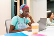 © Santi Nuñez/Stocksy - Trendy young woman using laptop in a coworking