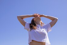 Anonymous Woman In White T-shirt Posing By Blue Sky 