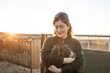 © Lupe Rodríguez/Stocksy - Young woman with puppy dogs on a farm