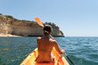 © David Prado/Stocksy - Woman in bikini sitting on kayak in sea