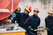 © Pedro Merino/Stocksy - Firefighters meeting while working