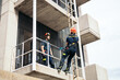 © Pedro Merino/Stocksy - Firefighters climbing a building with a harness and ladder