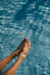 © Olga Moreira/Stocksy - Female feet in the swimming pool