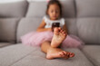 © Lupe Rodríguez/Stocksy - little girl with mobile phone sitting on sofa