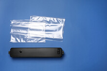 Sealer For Vacuum Packing With Plastic Bags On Blue Background, Flat Lay. Space For Text