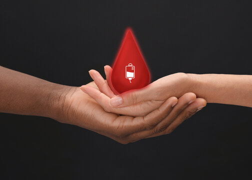 People holding red drop in hands on dark background, closeup. Blood donation concept