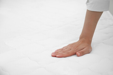 Wall Mural - Woman touching soft white mattress, closeup. Space for text