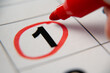 © Grustock - The calendar 1st day of the month is circled. A red marker circles the first day of the paper calendar. A very important date in the calendar