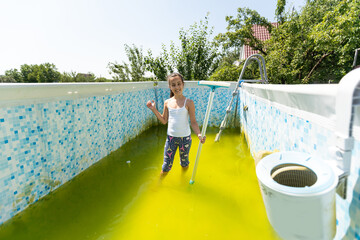 a little girl cleans a very dirty pool