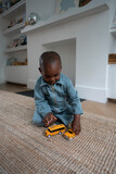 Fototapeta Londyn - Boy (2-3) playing with toy cars