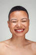 © Cultura Creative - Studio portrait of shirtless woman laughing with eyes closed