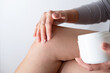 © Irina - Close up of a person rubbing cream for healing injured knee joint. Bruise on the knee. Leg pain.