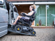 © Cultura Creative - Woman in electric wheelchair getting in van