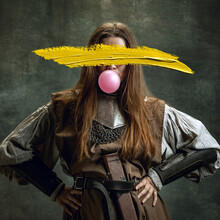 Young Woman As Medieval Warrior Wearing Historical Outfit With Yellow Stroke Of Paint On Her Face. Contemporary Artwork. Eras Comparison Concept
