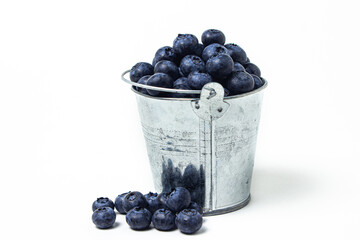 Poster - Blueberries on a white background. Small steel bucket full of blueberries. Useful and tasty berry.