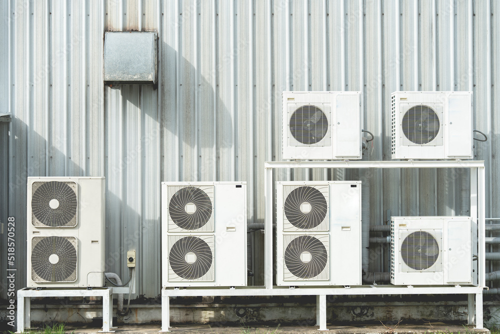 Condenser unit or compressor on roof of industrial plant building with ...