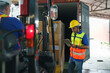 © ake1150 - Asian forklift driver loading a shipping cargo container with a full pallet with boxes in logistics port terminal. Asian warehouse worker and safety inspector with digital tablet manage the process.