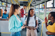 Multiracial group of female friends talking while riding in a bus