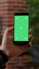 Poster - vertical video: businessman analyzing smartphone with greenscreen display in startup office. looking