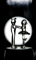 Sticker - Vertical black and white shot of two glass figurines in a blurred background