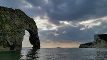 Closeup Of The Durdle Door Arch Surrounded By The Bay Water Against Gloomy Clouds In Dorset, England