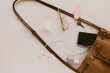 © Aubrey Westlund/Wirestock Creators - Contents of woman's purse spilling against the pink background