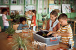 © Drazen - Elementary students learning botany while planting in the classroom.