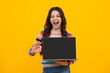 Amazed teenager. Student school girl with laptop on isolated studio background. Screen of laptop computer with copyspace mockup. Excited teen schoolgirl.