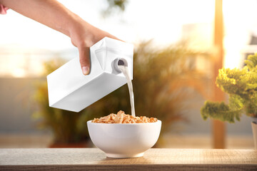 Hand with a container of milk in the breakfast