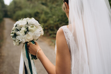 A beautiful bride holds her wedding bouquet