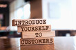 Wooden blocks with words 'INTRODUCE YOURSELF TO CUSTOMERS'. Business concept