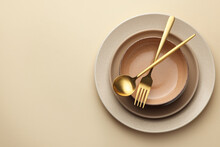 Stylish Empty Dishware And Cutlery On Beige Background, Top View. Space For Text