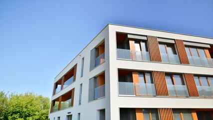 Wall Mural - Exterior of new apartment buildings on a blue cloudy sky background. No people. Real estate business concept.