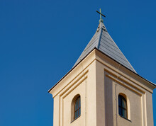 Side View Of A Church Steeple Against A Bright Blue Sky