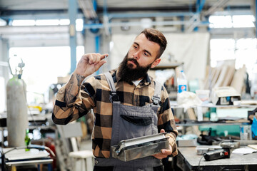 Wall Mural - An industry worker checking on bus construction in vehicle production factory.