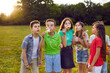 canvas print picture Little children enjoying holidays, playing in the park and having a great time together. Bunch of happy healthy kids standing on a green field on a warm summer day and blowing beautiful soap bubbles
