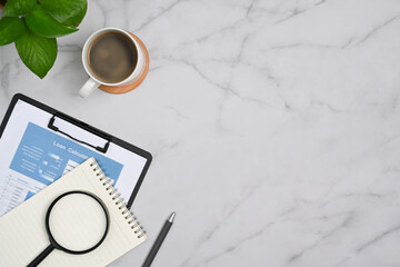 Poster - Top view financial document, magnifying glass, coffee cup and notepad on marble background with copy space