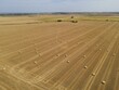 Drone high view of sunny day UK field with hay bales