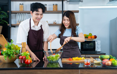 asian couple cooking at kitchen