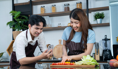 asian couple cooking at kitchen