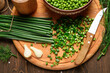 green onion, sweet peas on a dark wooden background, still life, concept of fresh and healthy food